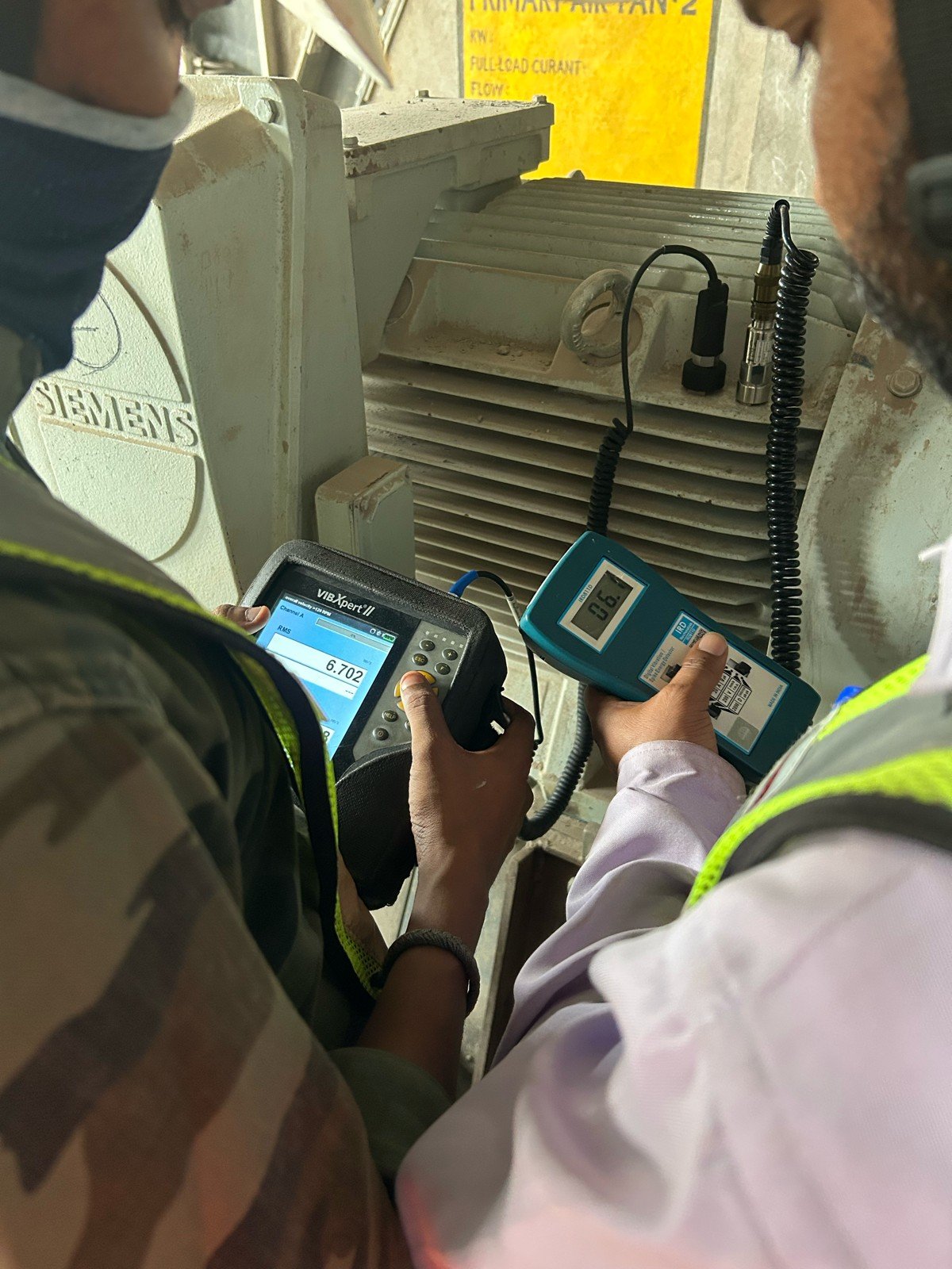 Technicians measuring motor vibration with portable meters
